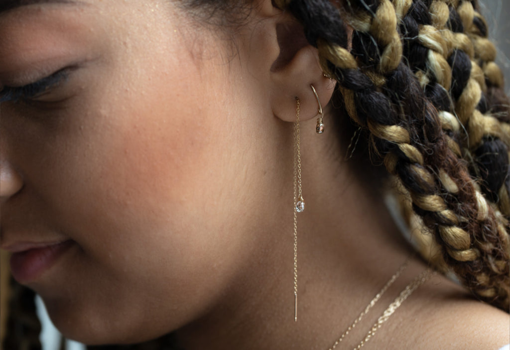 simple diamond drop threader earrings stacked on model