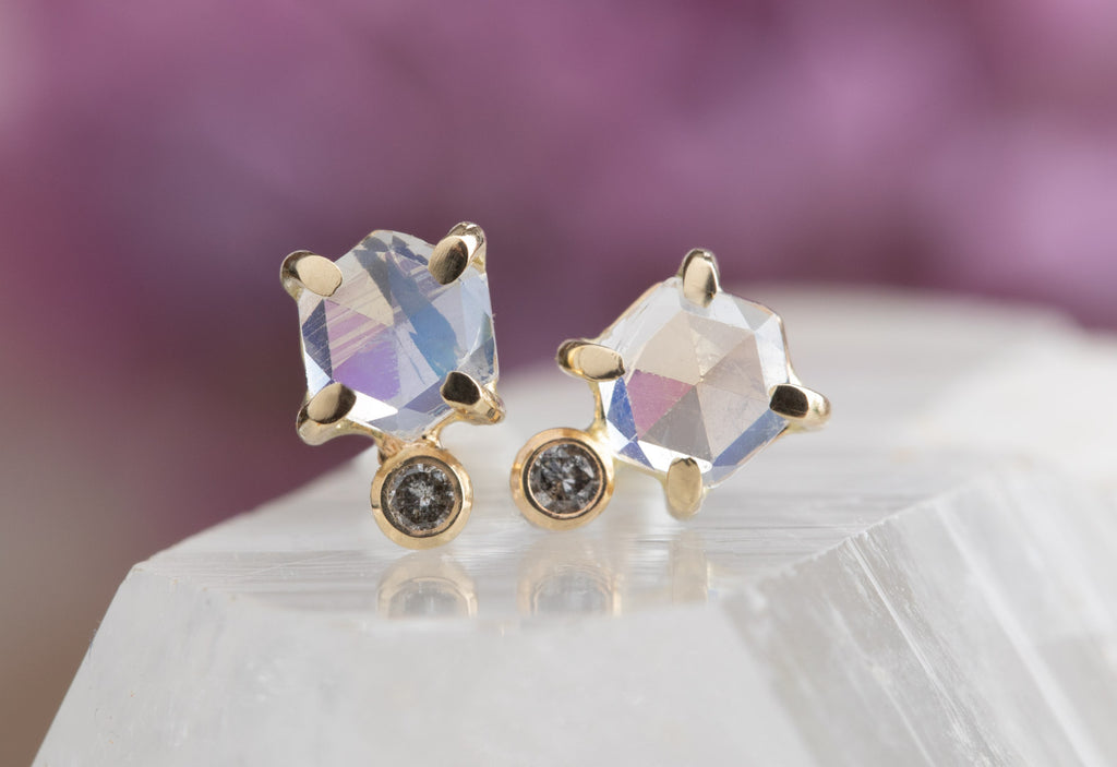 Moonstone Hexagon + Diamond Stud Earrings with pink flowers blurred in background