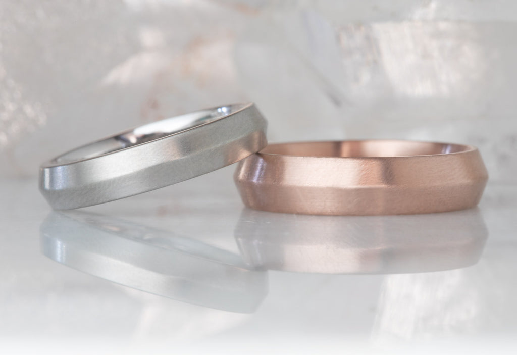 White and Rose Gold The Knife Edge Wedding Bands on White Marble Tile