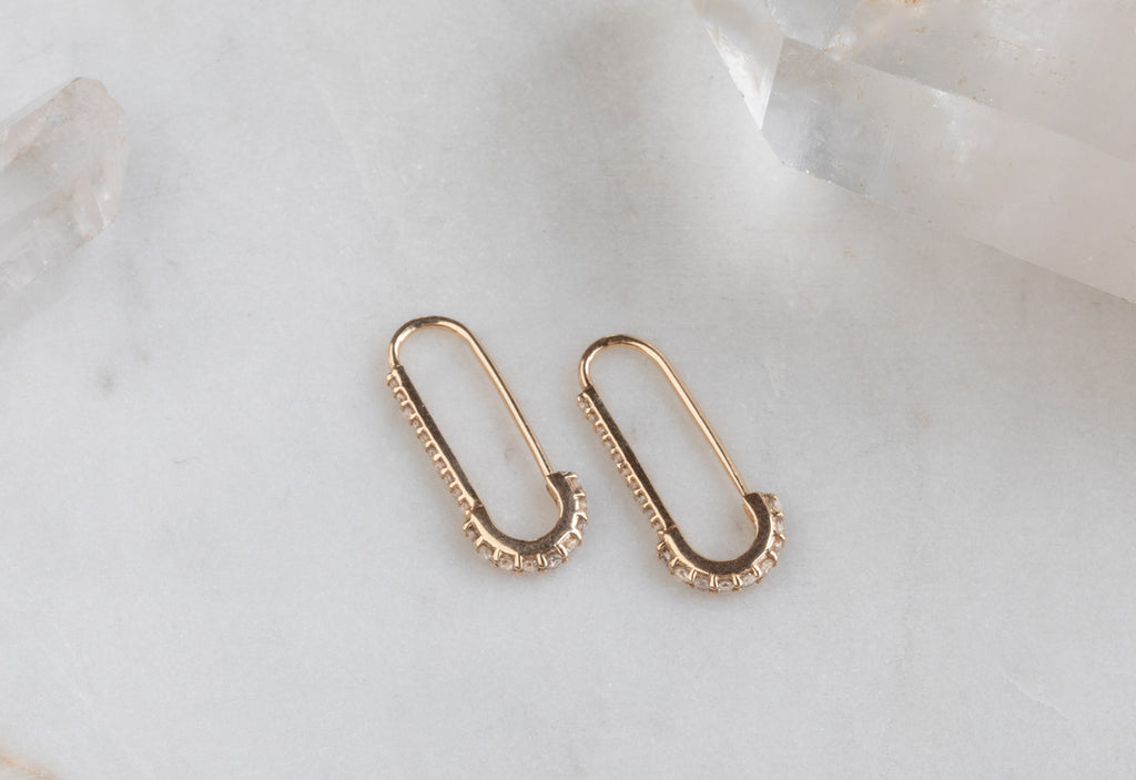 Yellow Gold Pavé Diamond Pin Earrings on white marble tile