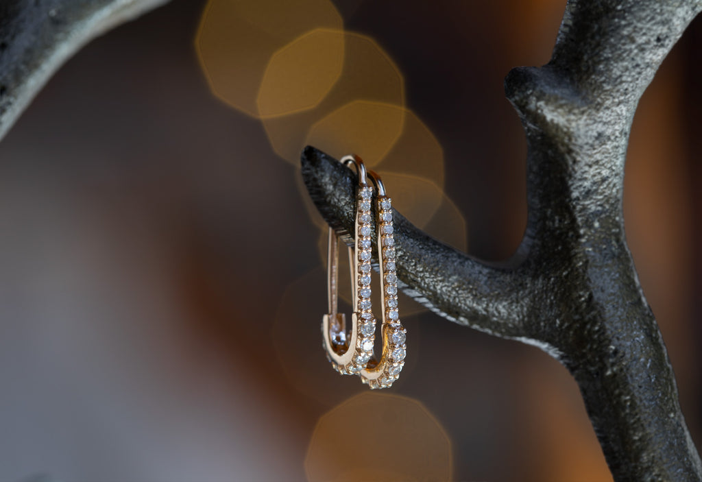 Yellow Gold Pavé Diamond Pin Earrings hanging on iron earring tree