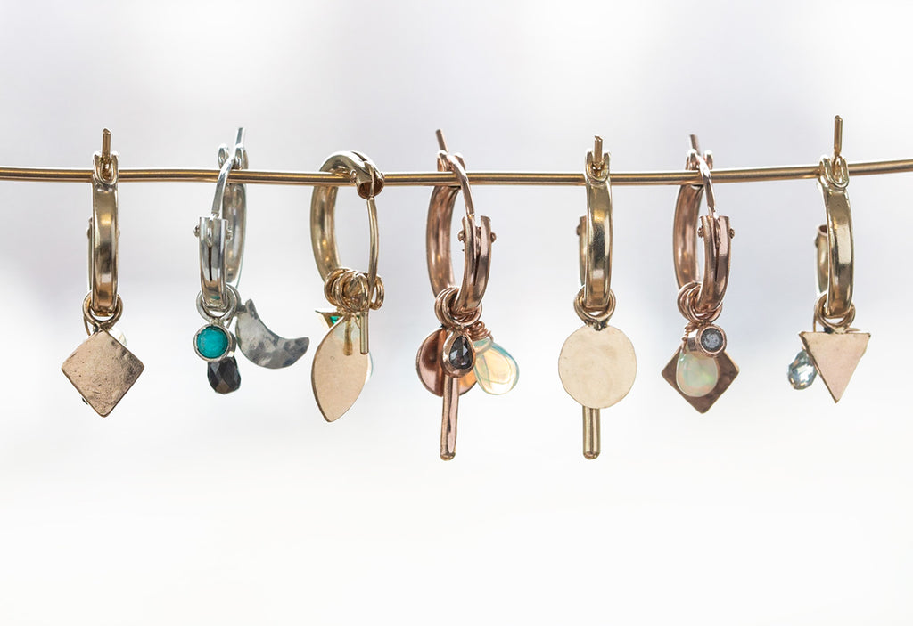 Custom charm hoop earrings hanging on yellow gold wire