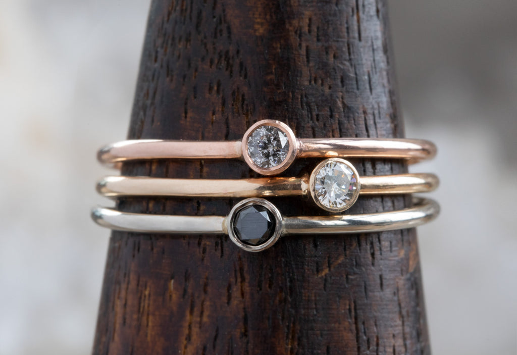 Three Teensy Custom Diamond Stacking Rings on wooden ring mandrel