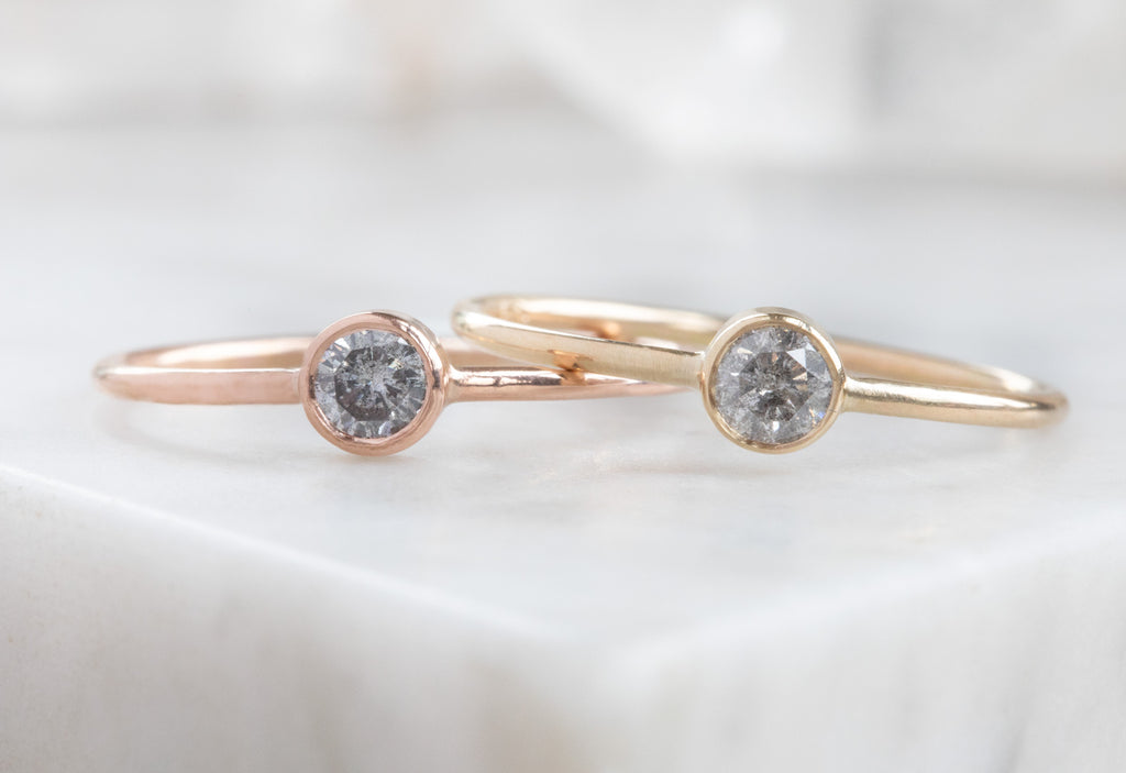 yellow and rose gold Round Salt and Pepper Diamond Stacking Rings on white marble tile