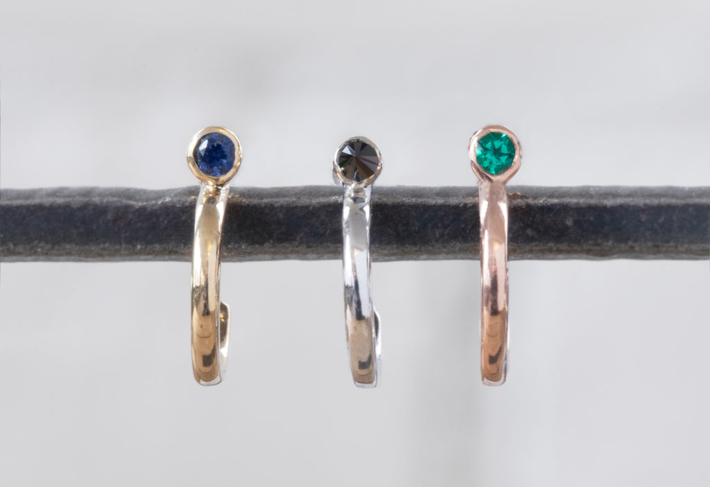 sapphire, black diamond and emerald birthstone huggie hoop earrings on iron earring tree