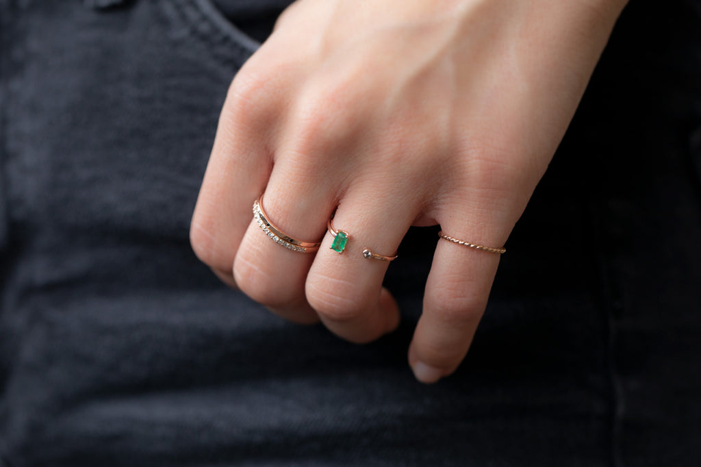 Open Cuff Emerald and Diamond Ring stacked on Model with hand in pocket