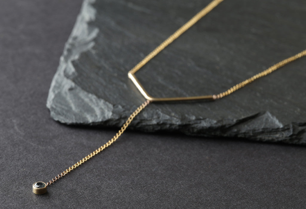 Yellow Gold Peak Sapphire Lariat Necklace on black slate