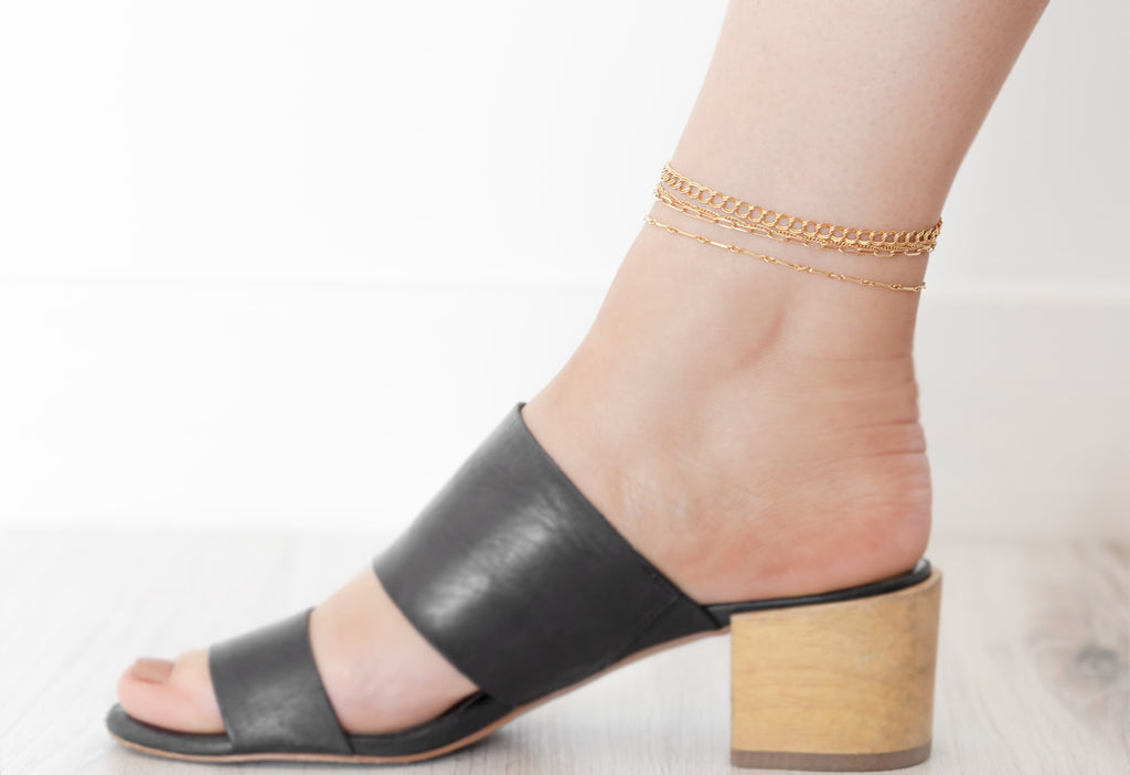Model Wearing All Anklet Chain Styles in Black Mule Sandals