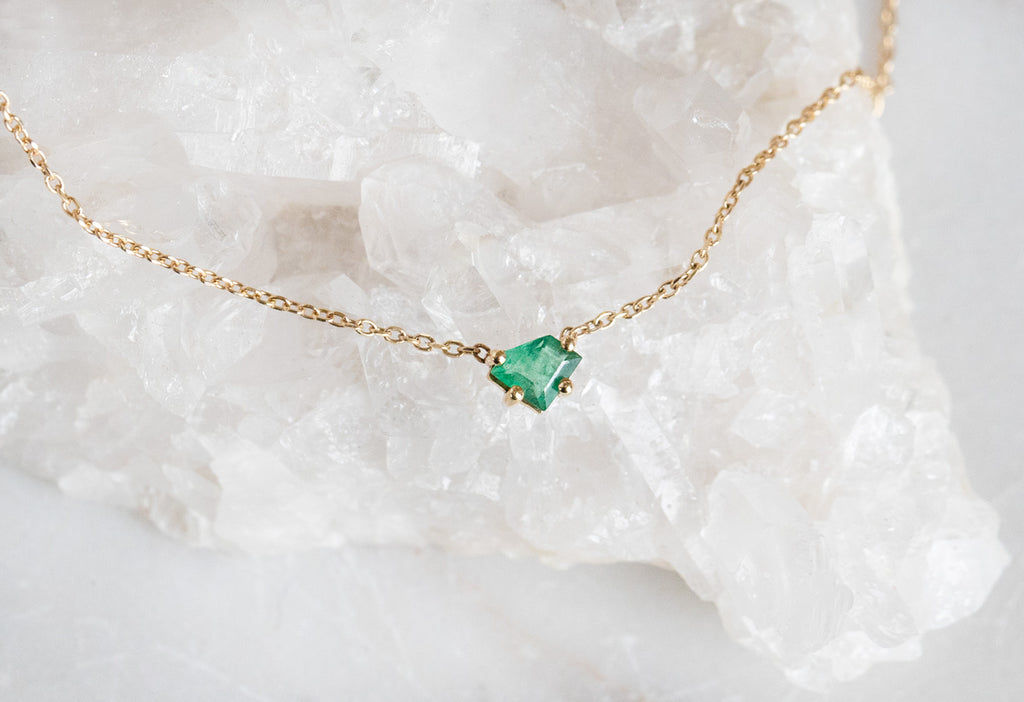 Geometric Emerald Necklace Laying On Crystal