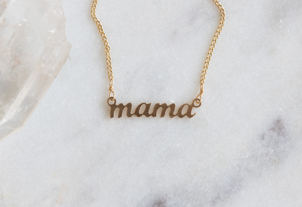 Mama necklace on white marble tile