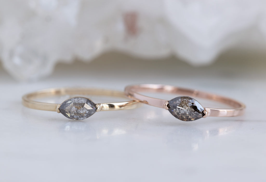 Yellow and Rose Gold Salt and Pepper Diamond Eye Rings on White Marble Tile 