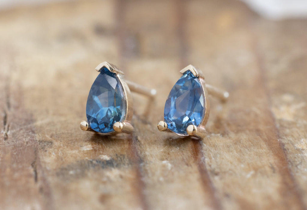Montana Sapphire Stud Earrings in Yellow Gold on Wood Table