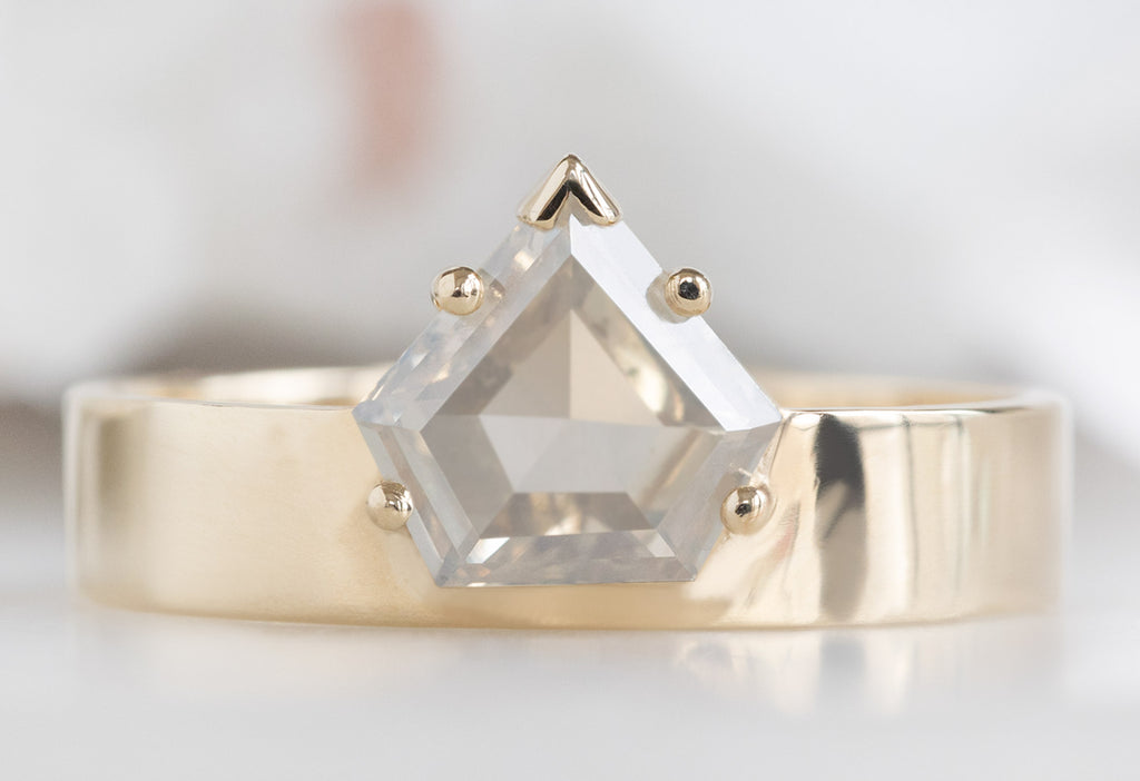 One Of A Kind Cigar Band with a Shield-Cut Opalescent Diamond on White Marble Tile