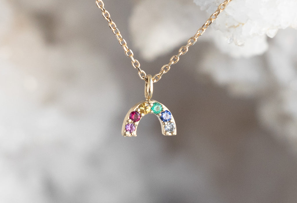 Rainbow Sapphire Charm Necklace Hanging on White Crystal