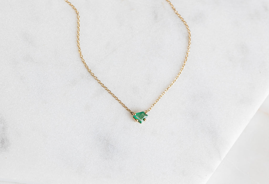 Geometric Emerald Necklace laying on marble