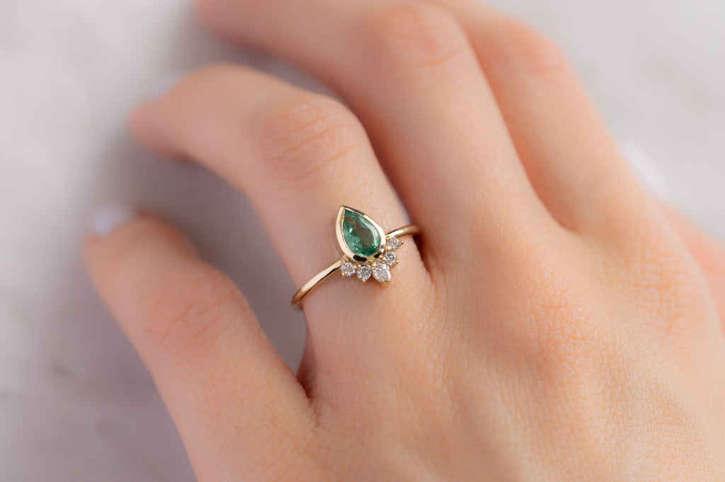 The Aster Ring with a Pear-Cut Emerald on Model