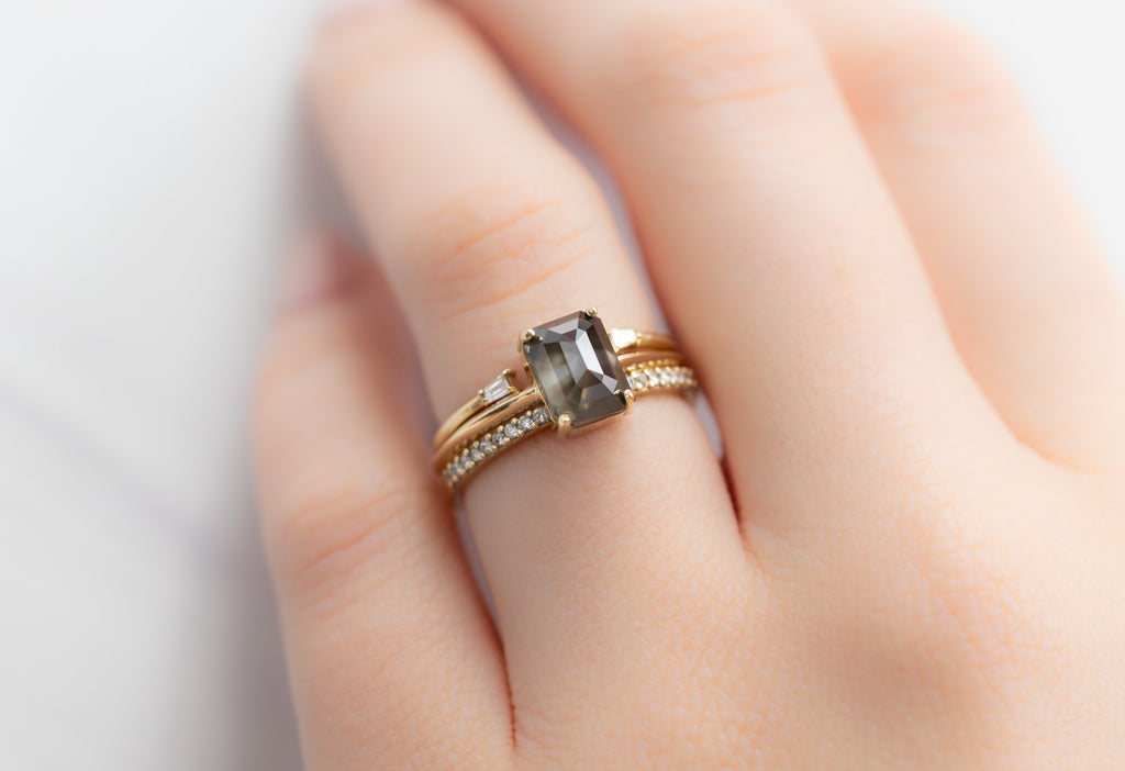 The Bryn Ring with an Emerald-Cut Black Diamond with Stacking Bands on Model