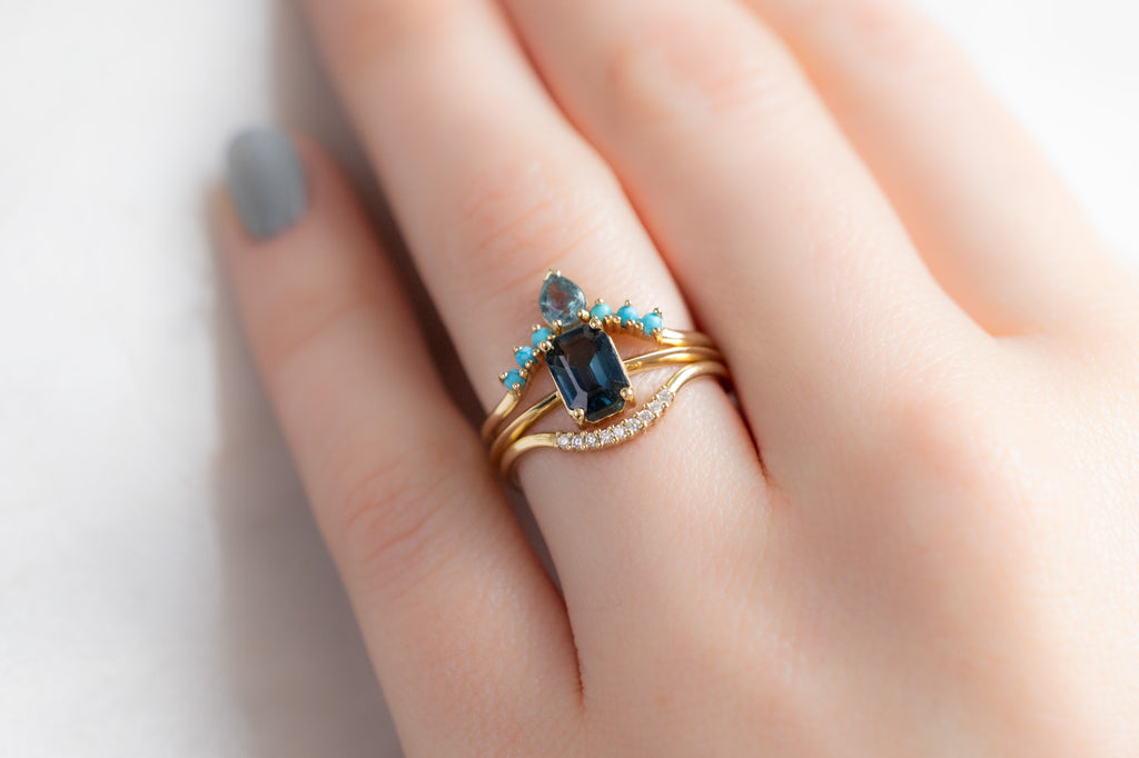 The Bryn Ring with an Emerald-Cut Montana Sapphire with Stacking Bands on Model