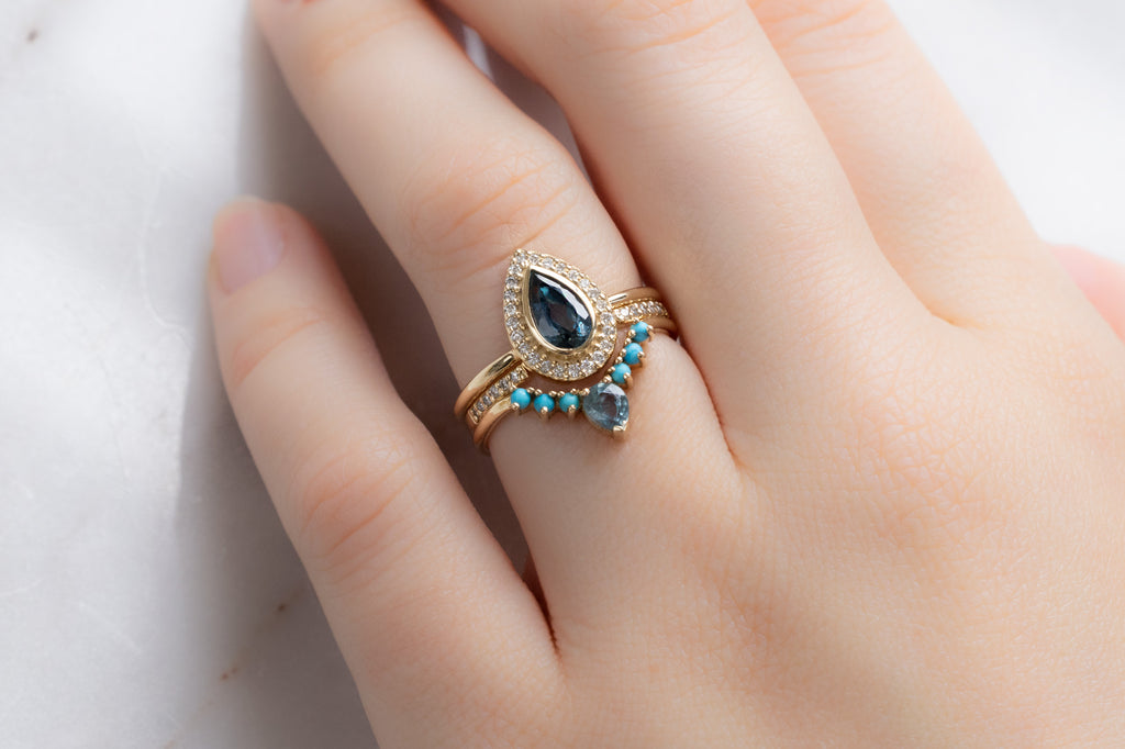 The Dahlia Ring with a Pear-Cut Sapphire with Stacking Bands on Model