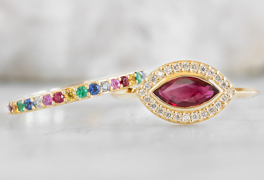 The Dahlia Ring with a Ruby Marquise with Rainbow Sapphire Eternity Band