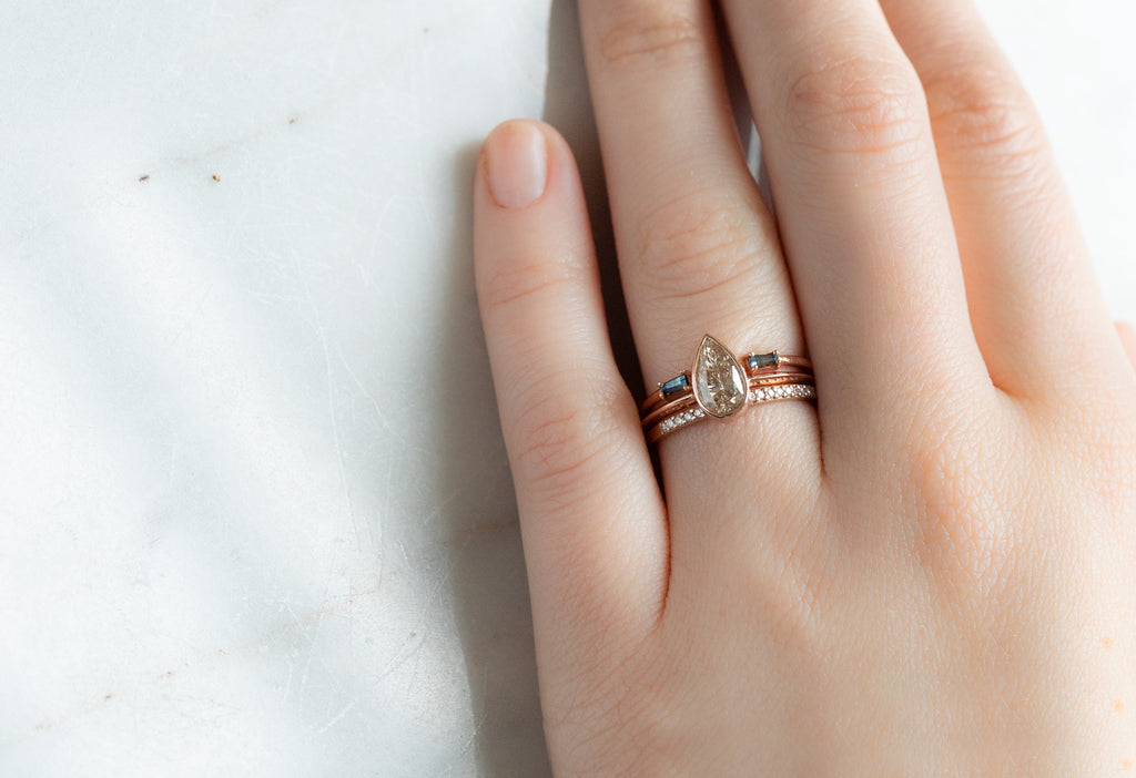 The Hazel Ring with a Pear-Cut Pink Diamond with Stacking Bands on Model