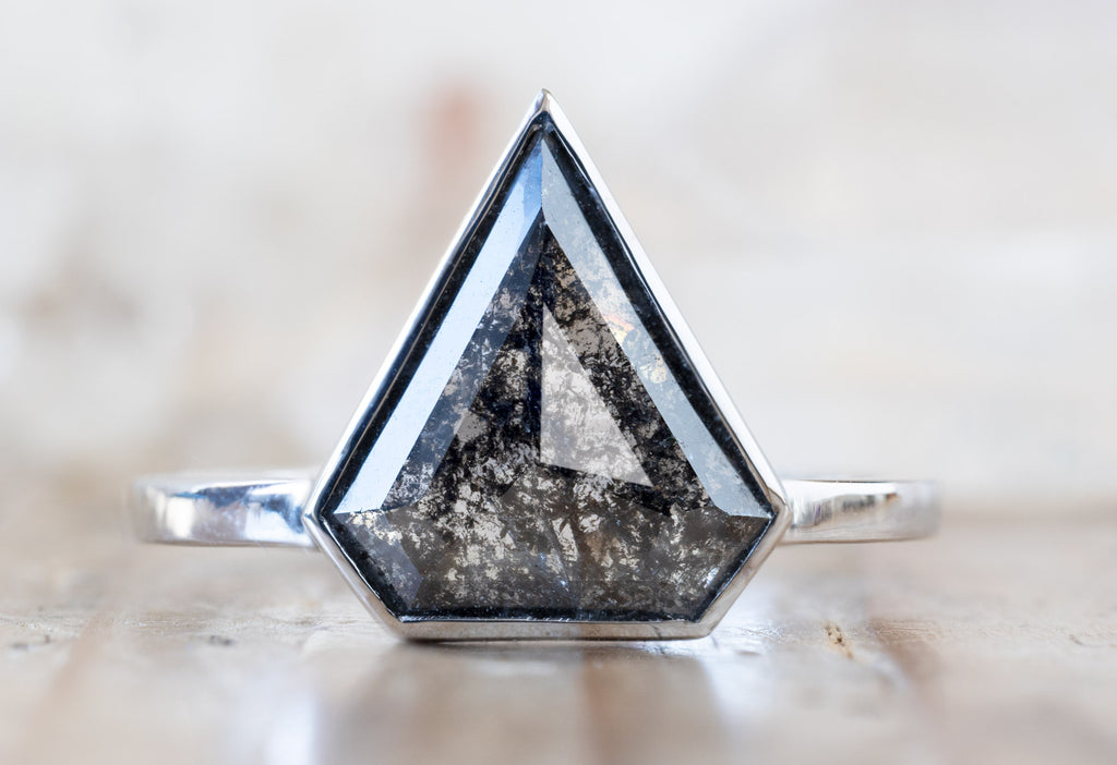 The Hazel Ring with a Shield-Cut Black Diamond on Wooden Table