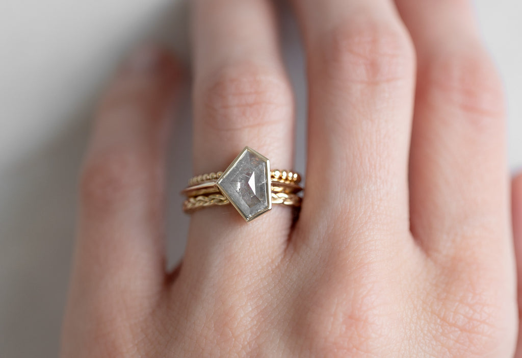 The Hazel Ring with a Silvery-Grey Shield-Cut Diamond with Stacking Bands on Model