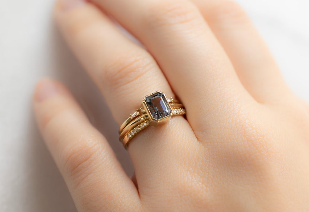 The Hazel Ring with an Emerald-Cut Spinel with Stacking Bands on Model