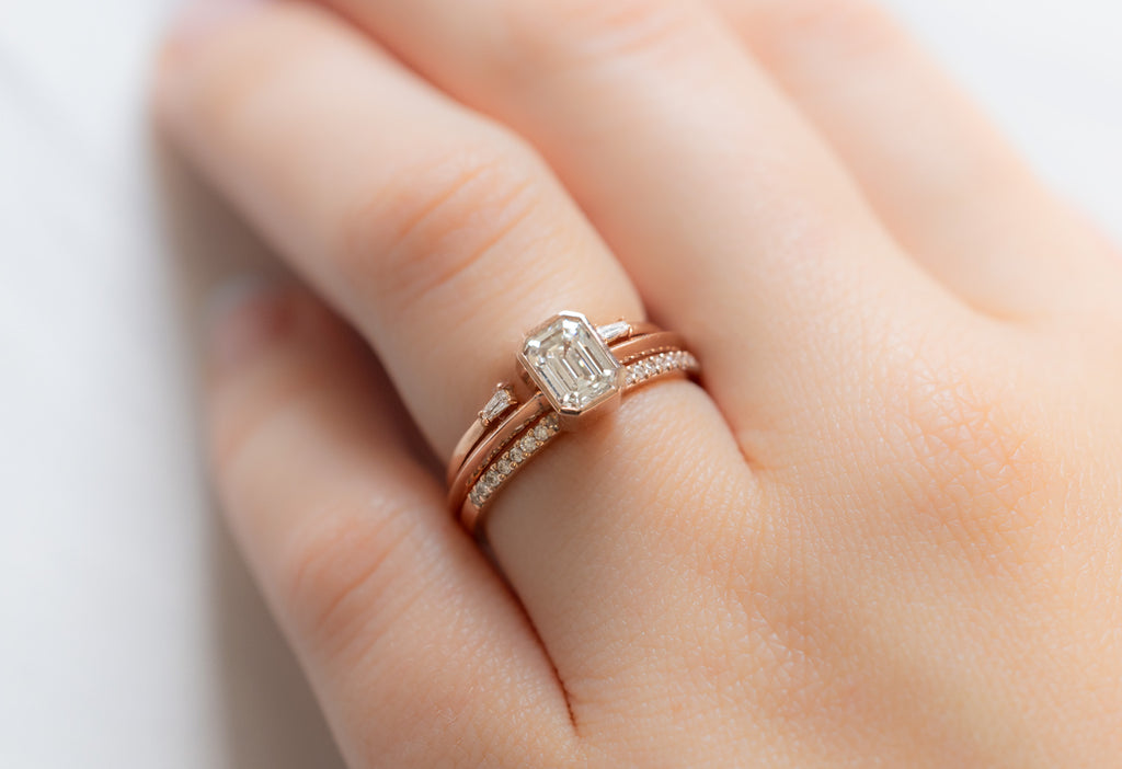 The Hazel Ring with an Emerald-Cut White Diamond with Stacking Bands on Model