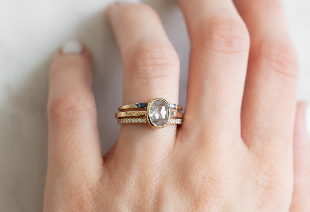 The Hazel Ring with an Oval-Cut Salt and Pepper Diamond with Stacking Bands on Model