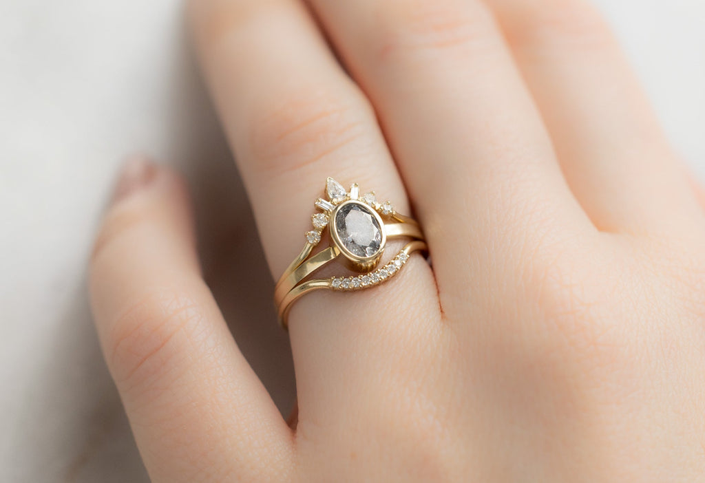 The Hazel Ring with an Oval-Cut Salt and Pepper Diamond with Stacking Bands on Model