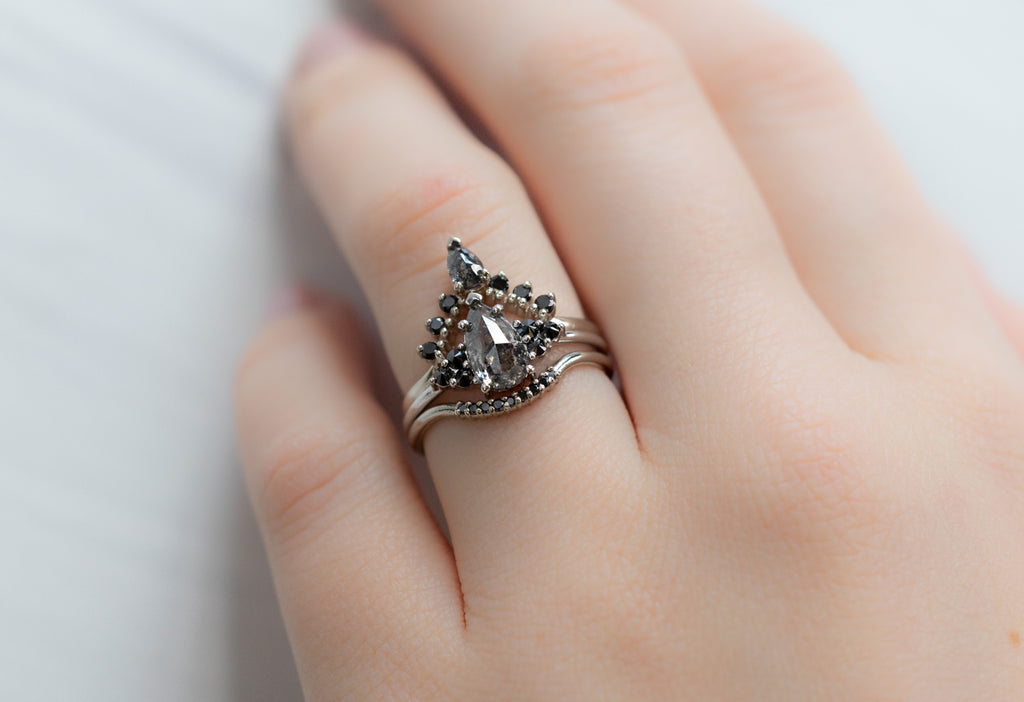 The Ivy Ring with a Black Pear-Shaped Diamond with Black Diamond Stacking Bands