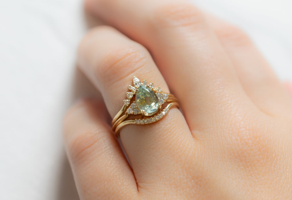 The Ivy Ring with a Pear-Cut Bicolor Sapphire with Stacking Bands on Model