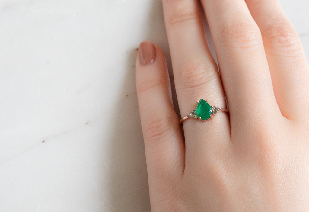 The Ivy Ring with a Pear-Cut Emerald on Model