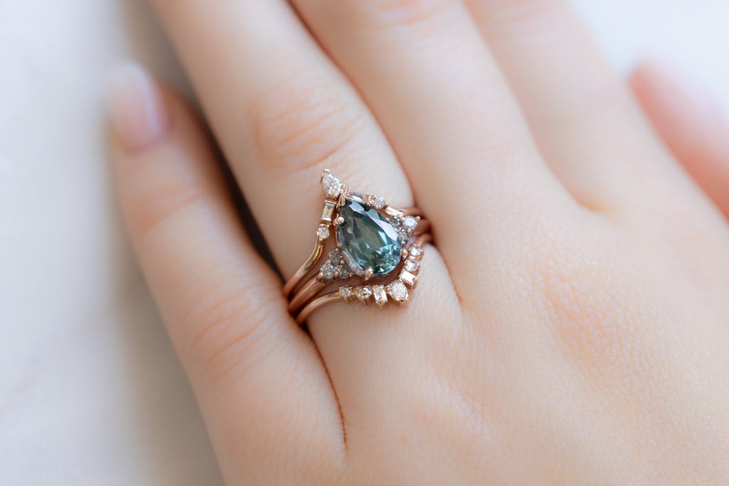 The Ivy Ring with a Pear-Cut Montana Sapphire with White Diamond Stacking Bands on Model
