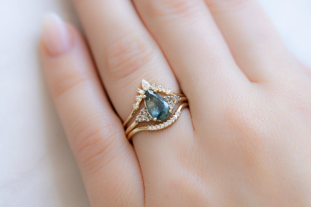 The Ivy Ring with a Pear-Cut Montana Sapphire with White Diamond Stacking Bands on Model
