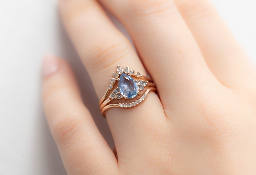 The Ivy Ring with a Pear-Cut Montana Sapphire with White Diamond Stacking Bands on Model