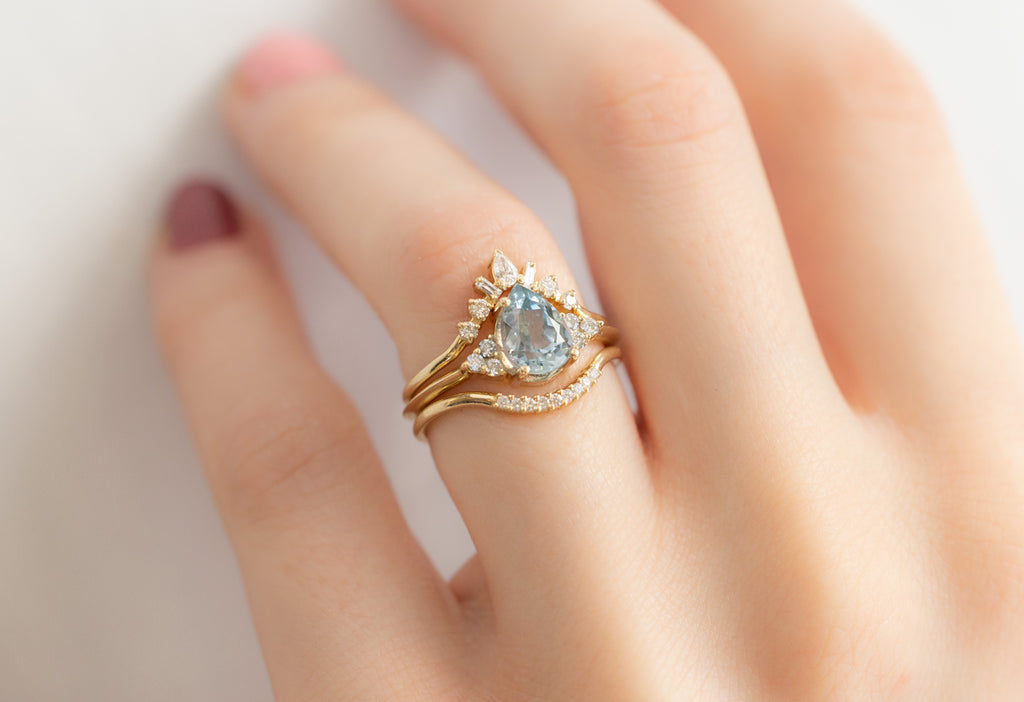 The Ivy Ring with a Pear-Cut Sapphire with White Diamond Stacking Bands on Model