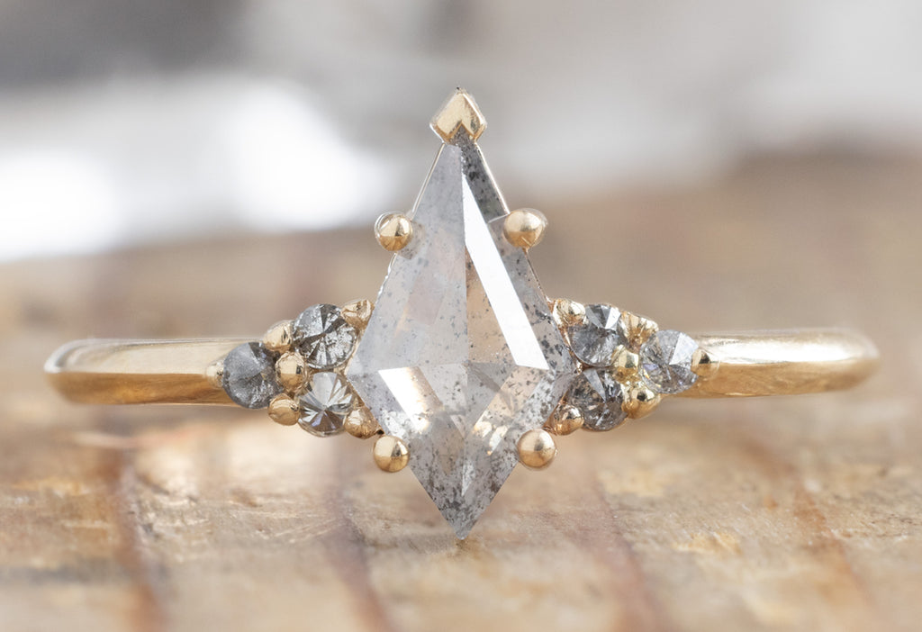 The Ivy Ring with a Silvery-Grey Kite-Shaped Diamond on Wood Table
