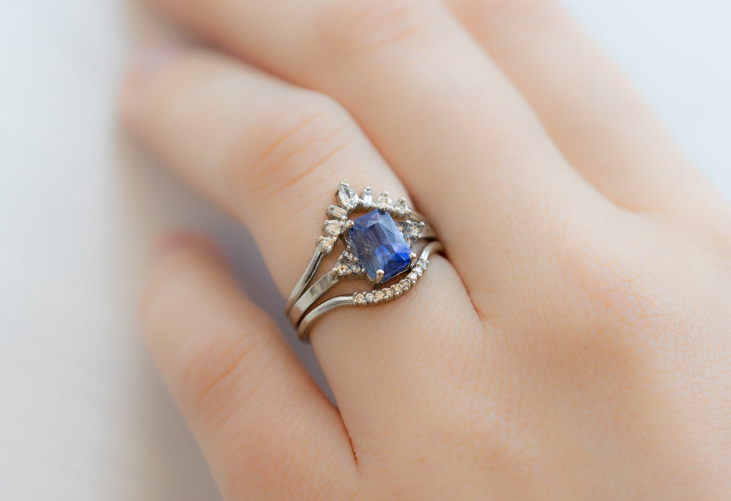 The Ivy Ring with an Emerald-Cut Sapphire with Stacking Bands on Model