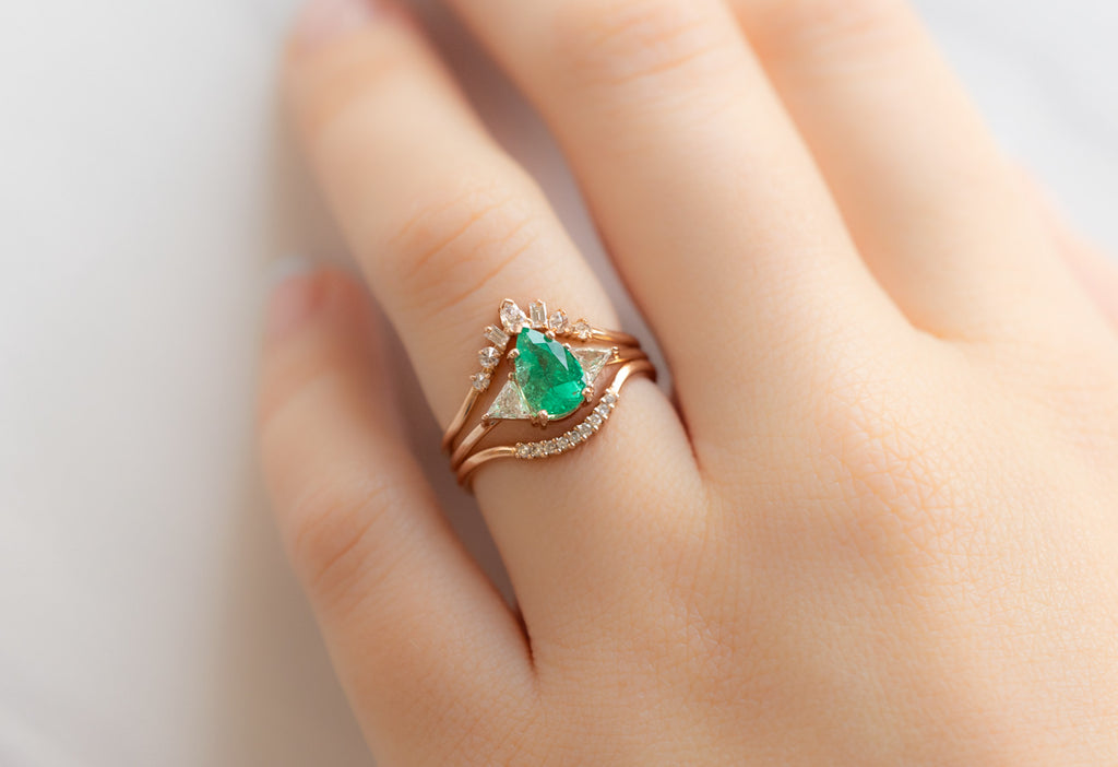The Jade Ring with a Pear-Cut Emerald with Stacking Bands on Model