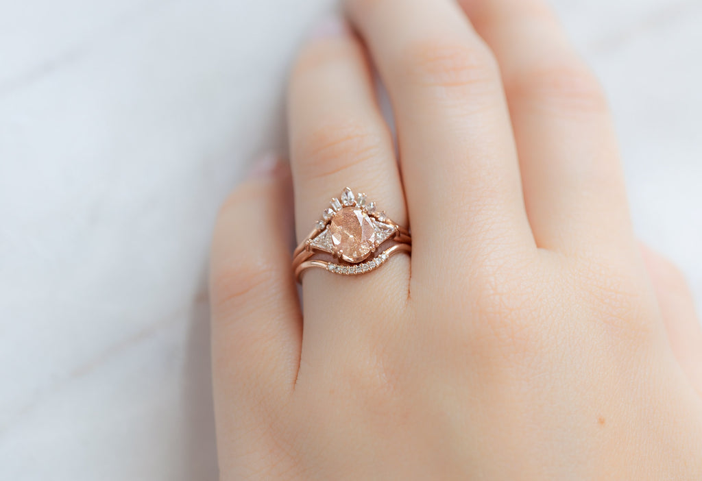 The Jade Ring with an Oval-Cut Sunstone with Stacking Bands on Model
