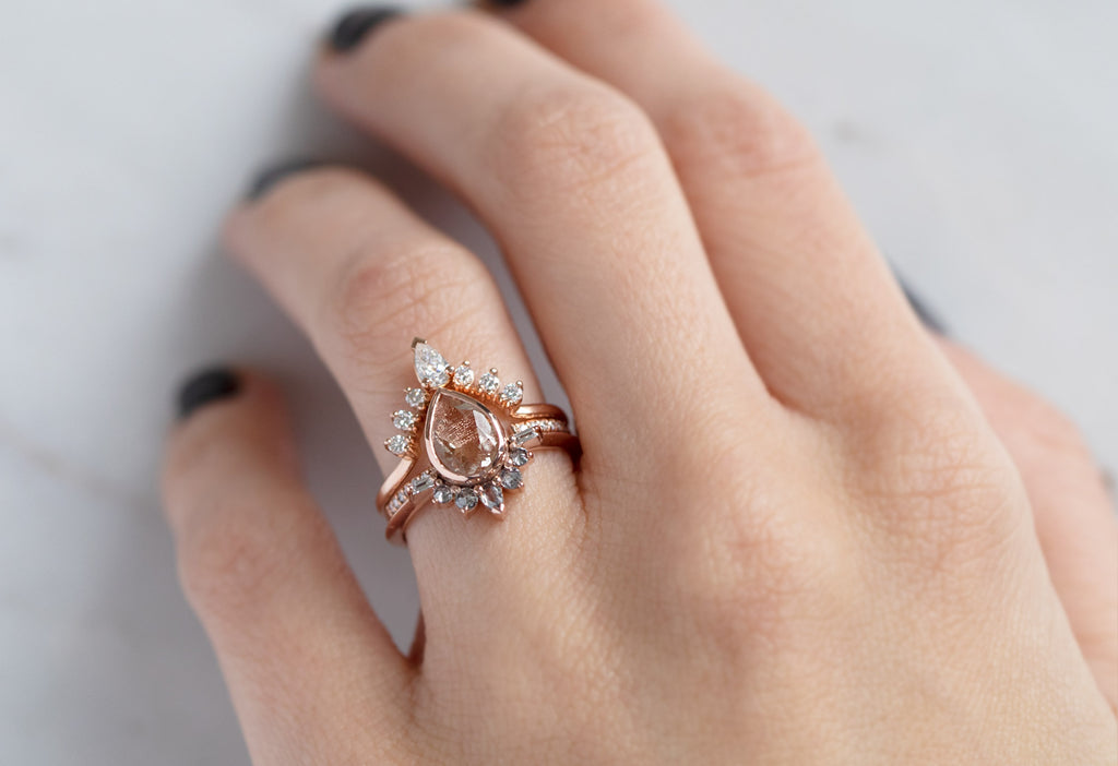 The Posy Ring with a Pear-Cut Sunstone with Stacking Bands on Model