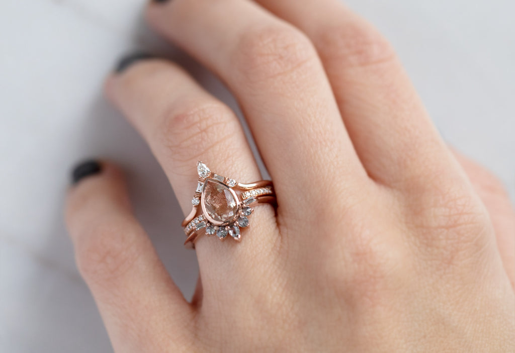 The Posy Ring with a Pear-Cut Sunstone with Stacking Bands on Model