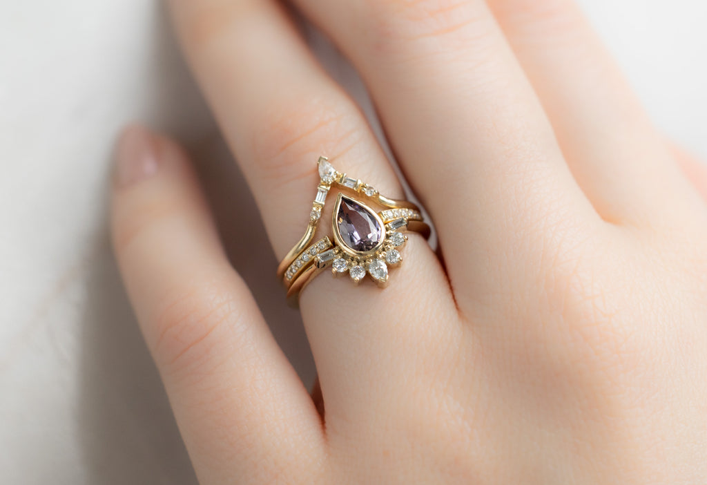 The Posy Ring with a Pear-Cut Tanzanite with White Diamond Stacking Bands on Model