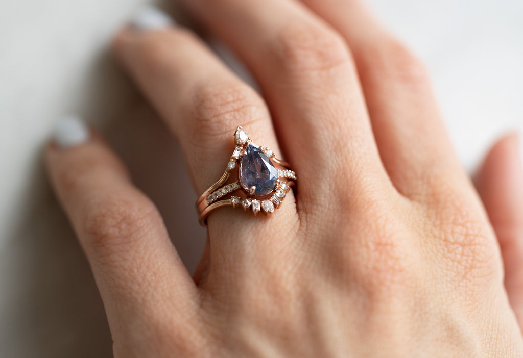 The Willow Ring with a Pear-Cut Grey-Violet Sapphire with Stacking Bands on Model