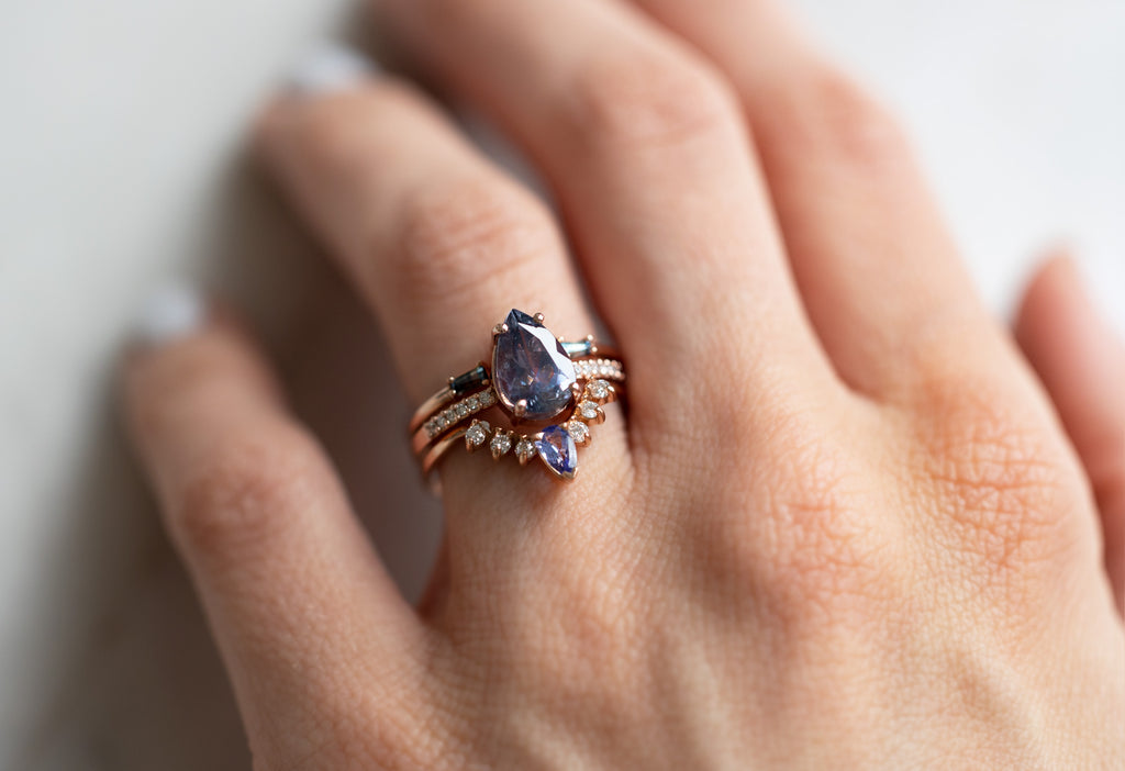 The Willow Ring with a Pear-Cut Grey-Violet Sapphire with Stacking Bands on Model