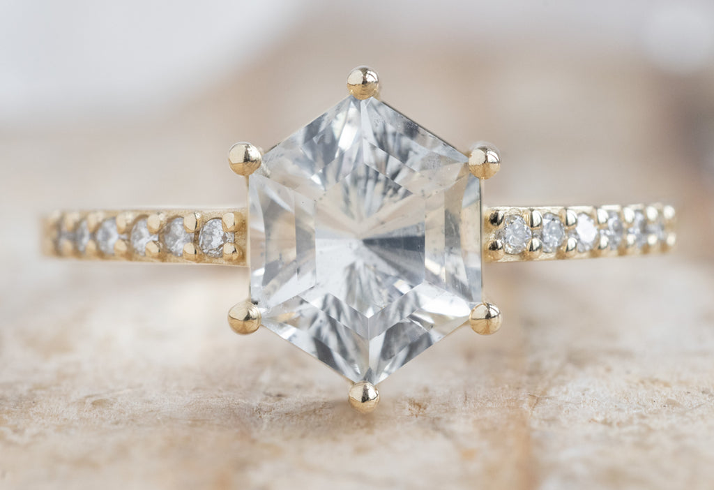 The Willow Ring with a White Sapphire Hexagon on Wooden Table