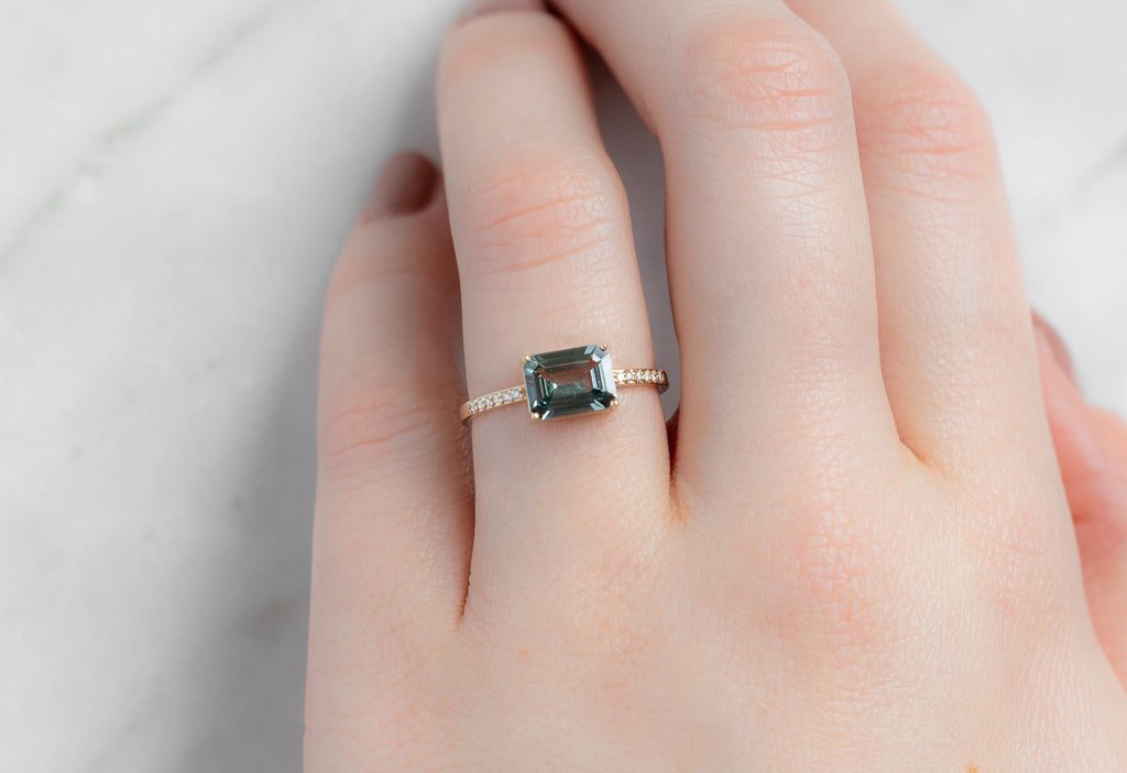 The Willow Ring with an Emerald-Cut Green Sapphire on Model