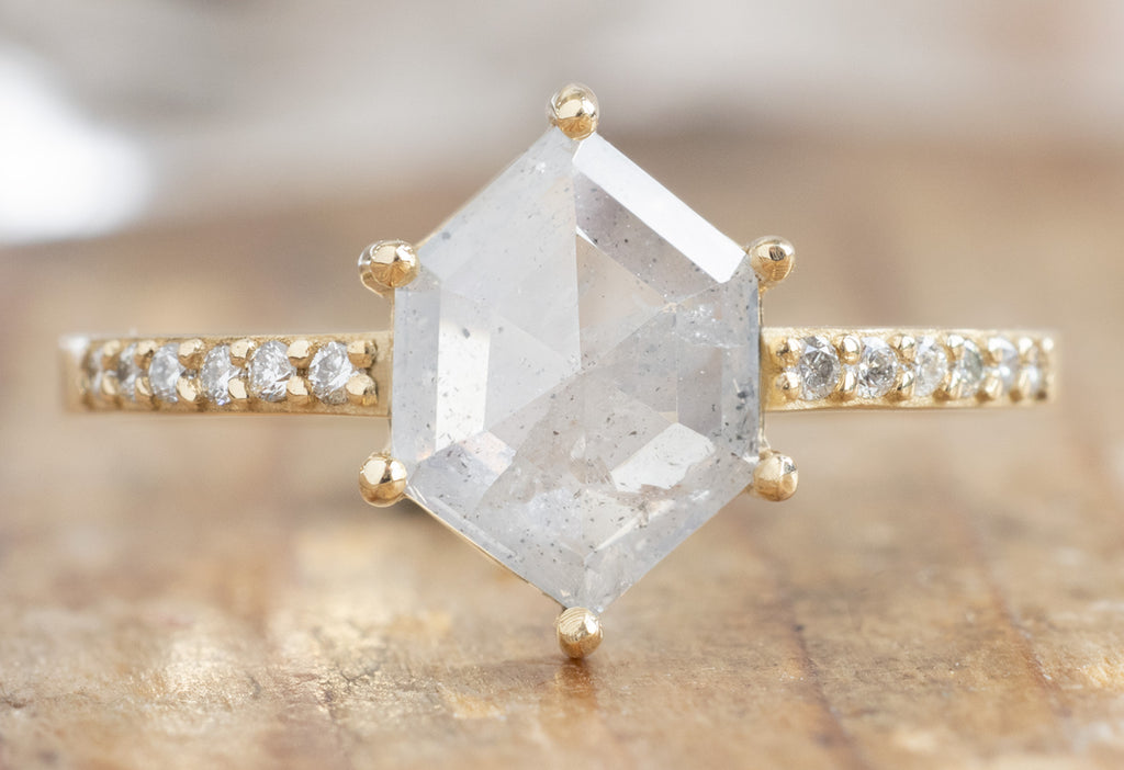 The Willow Ring with an Icy-White Hexagon Diamond on Wood Table